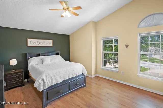 a bed sitting in a spacious bedroom next to a window