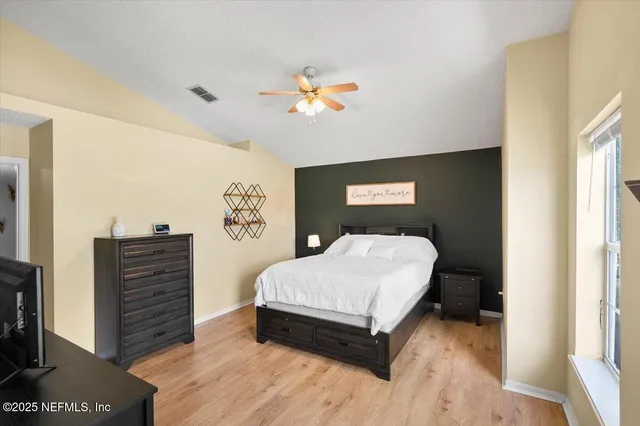 a bedroom with a bed and wooden floor