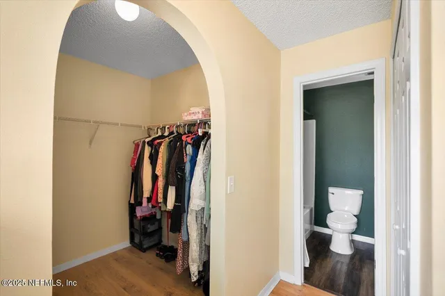 a view of walk in closet with clothes and shoes