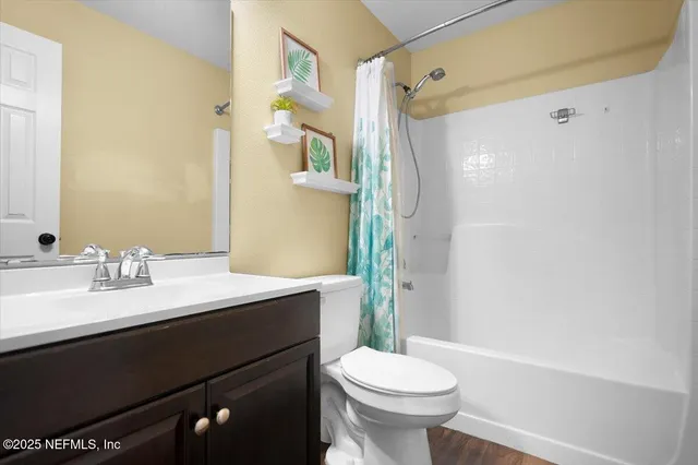 a bathroom with a sink a toilet a mirror and shower