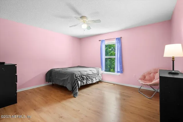 a bedroom with a bed dresser and a window