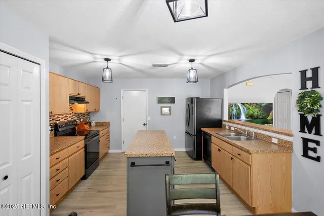 a large kitchen with stainless steel appliances granite countertop a stove and refrigerator