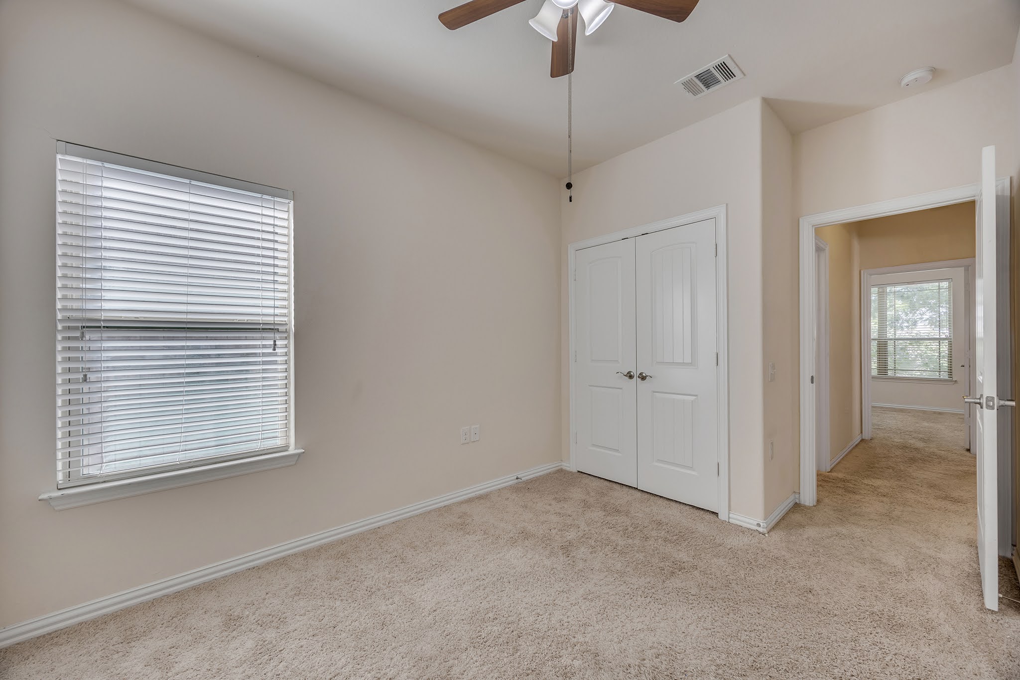 7212 Vail Ridge Street Austin, TX 78744 - Photo 13 of 26 A well-lit bedroom features plush carpeting and a convenient closet, ideal for comfortable living.