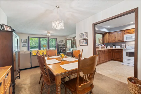 a dining room with furniture a chandelier and wooden floor
