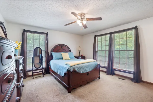 a bedroom with a bed and a large window