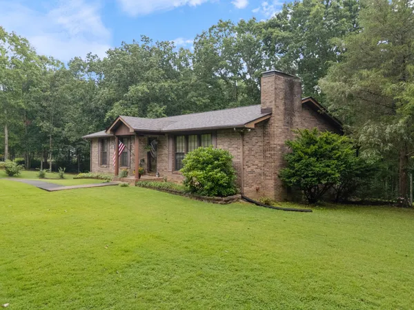 a view of a house with pool and a yard