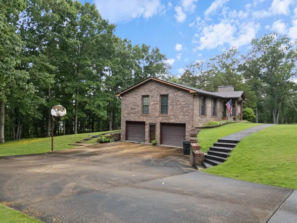a front view of a house with a yard and trees