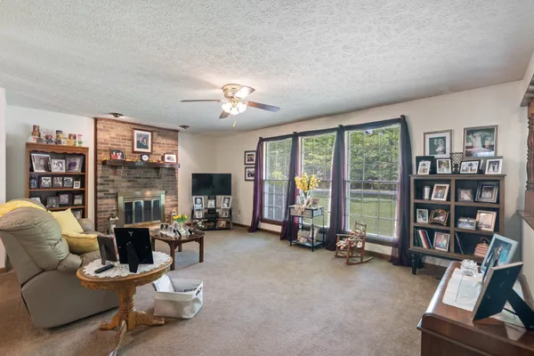 a living room with furniture a lamp and a large window