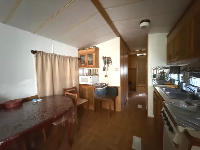 a kitchen with stainless steel appliances granite countertop sink table and chairs