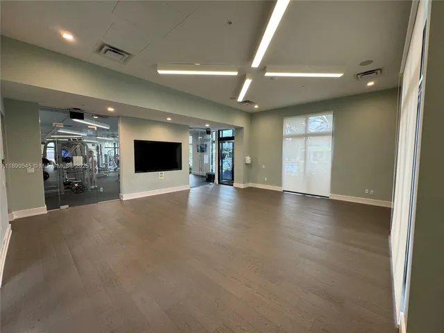 a view of a room with gym equipment and large windows