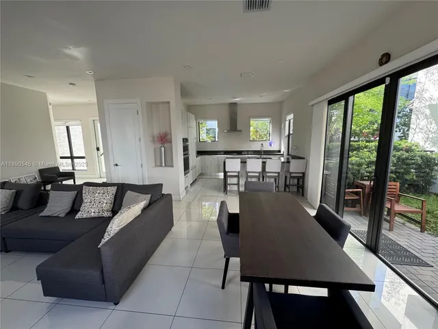 a living room with furniture wooden floor and a floor to ceiling window