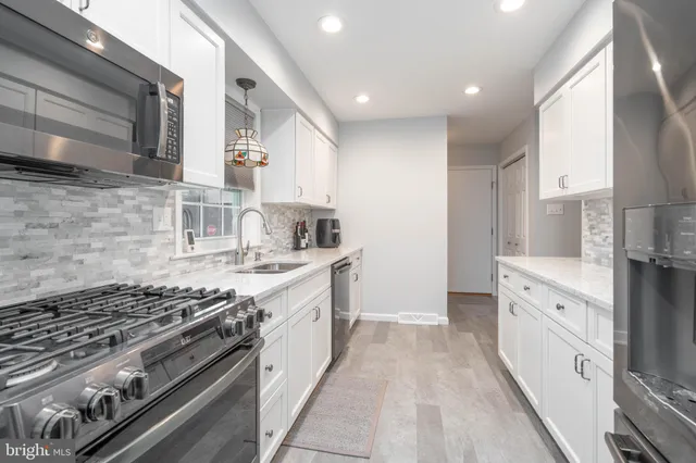 a kitchen with white cabinets and appliances