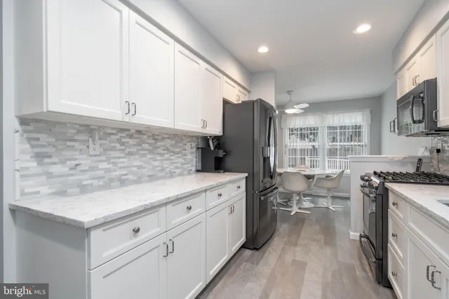 a kitchen with stainless steel appliances kitchen island granite countertop a sink stove and refrigerator