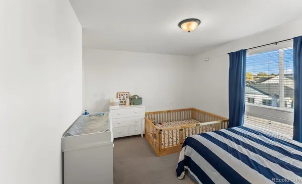 a bedroom with 2 bed and a window