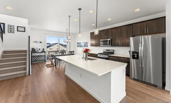 a kitchen with kitchen island white cabinets and stainless steel appliances
