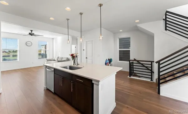a kitchen with a sink a stove and a wooden floor