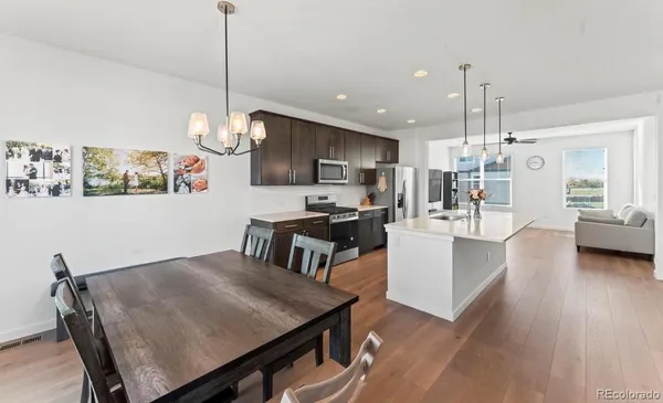 a view of a dining room and livingroom with furniture wooden floor a chandelier