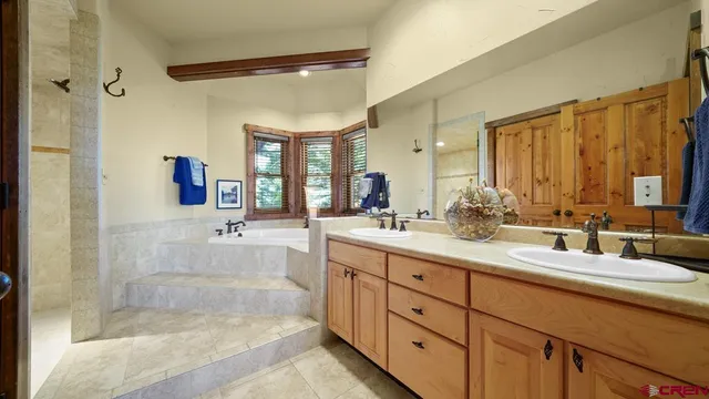 a bathroom with a tub sink and mirror