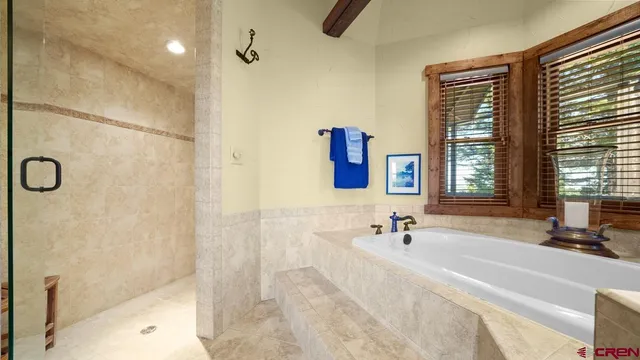a bathroom with a tub a sink a mirror and shower