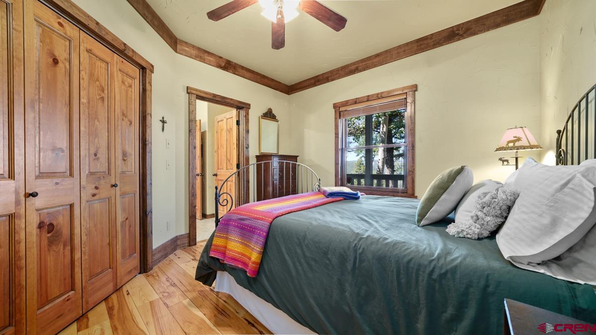 220 Ridge Road Cimarron, CO 81220 - Photo 18 of 45 a bedroom with a bed and a chandelier