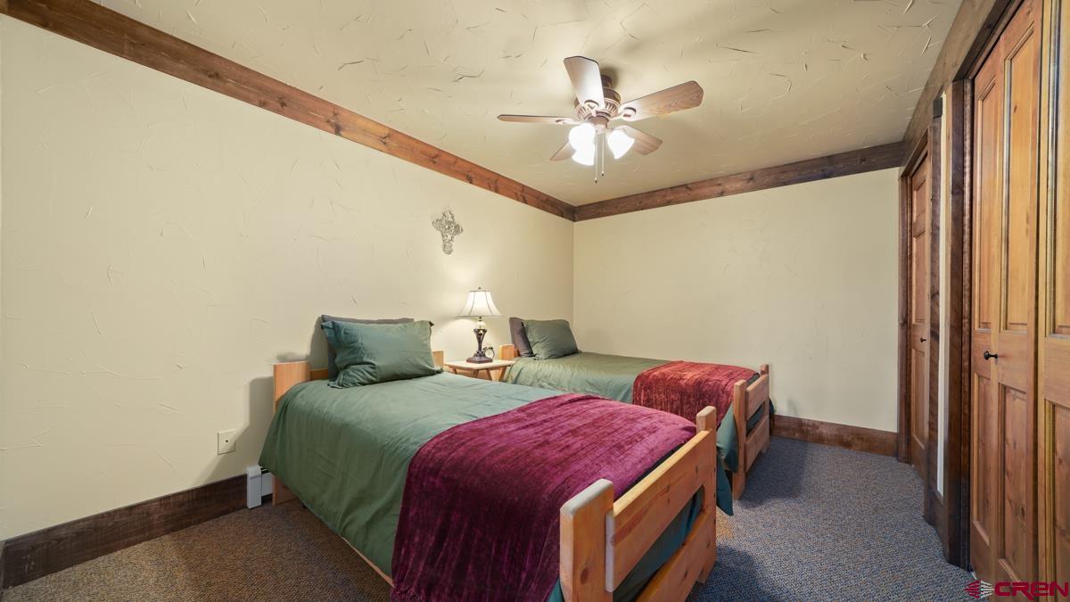 220 Ridge Road Cimarron, CO 81220 - Photo 22 of 45 a bedroom with a bed and a chandelier