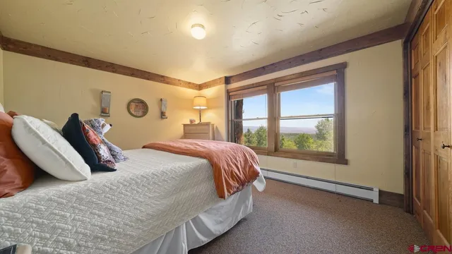 a bedroom with a bed and a large window