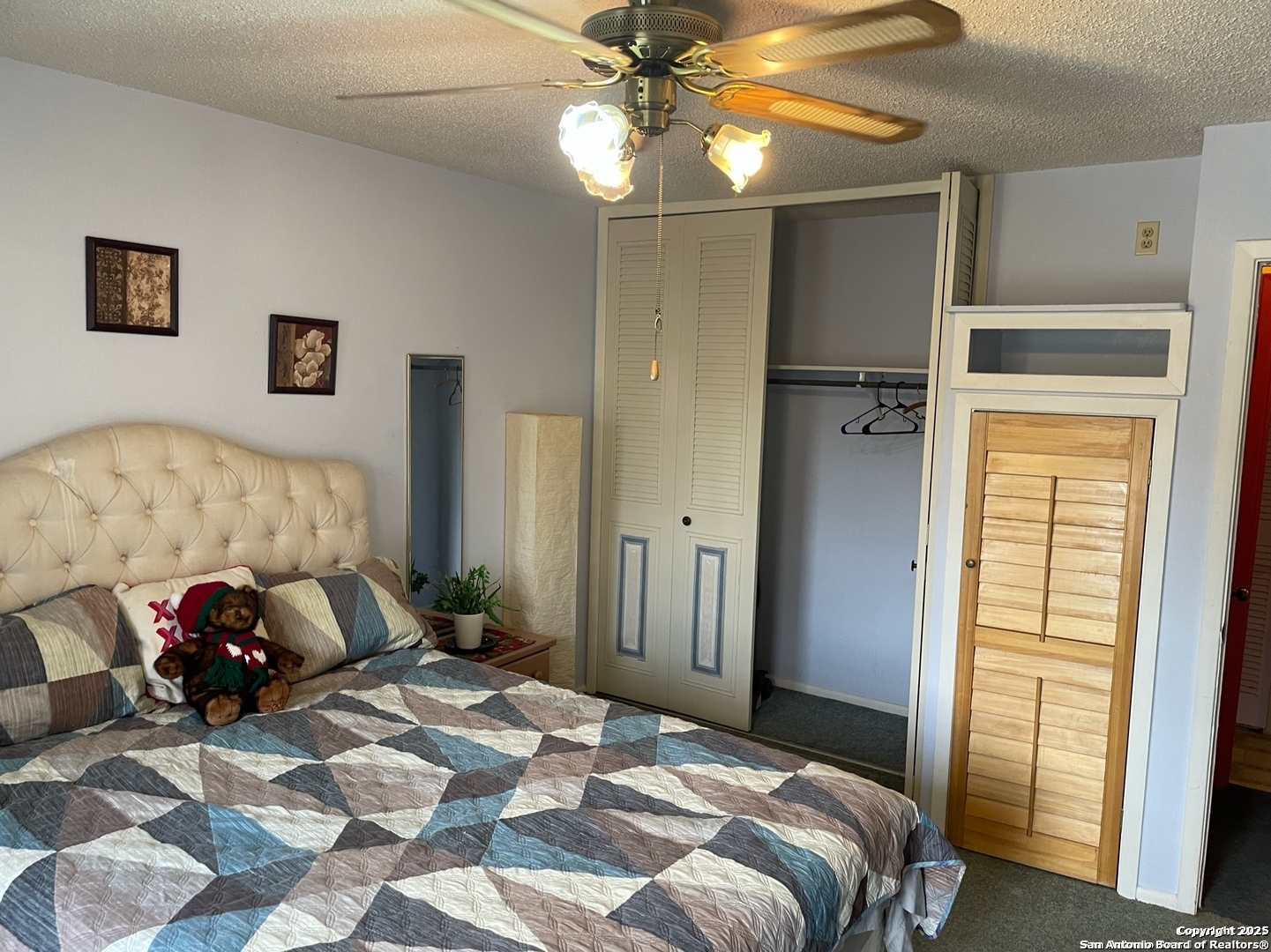 923 Vance Jackson Road, Unit 904 San Antonio, TX 78201 - Photo 8 of 11 a bedroom with a bed and a chandelier