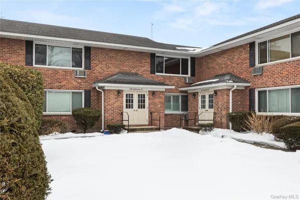 a front view of a house with a yard covered in snow