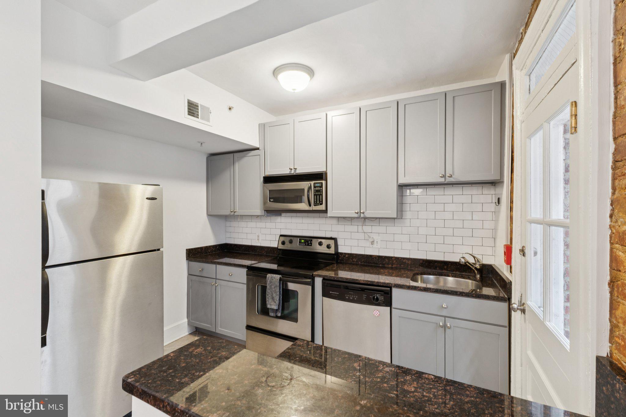 1858 California Street Northwest, Unit 5 Washington, DC 20009 - Photo 11 of 23 a kitchen with stainless steel appliances granite countertop a refrigerator sink and stove