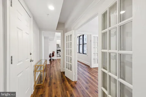 a view of a hallway with wooden floor and staircase