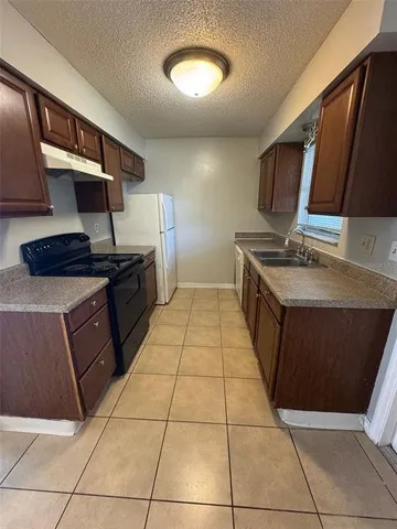 a kitchen with stainless steel appliances a stove a sink and a microwave