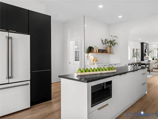 a kitchen with white cabinets a sink dishwasher and a stove with wooden floor