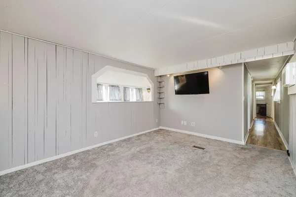a view of empty room with wooden floor and windows