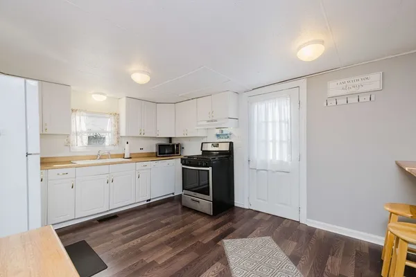 a kitchen with a sink cabinets stainless steel appliances and a window