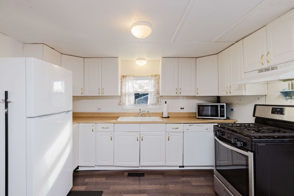 3040 Cranberry Highway, Unit 41 Wareham, MA 02538 - Photo 8 of 25 a kitchen with granite countertop white cabinets and white appliances