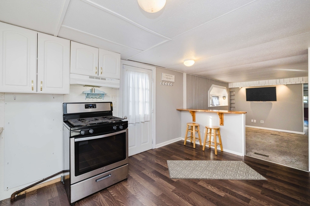 3040 Cranberry Highway, Unit 41 Wareham, MA 02538 - Photo 9 of 25 a kitchen with a stove a refrigerator and white cabinets
