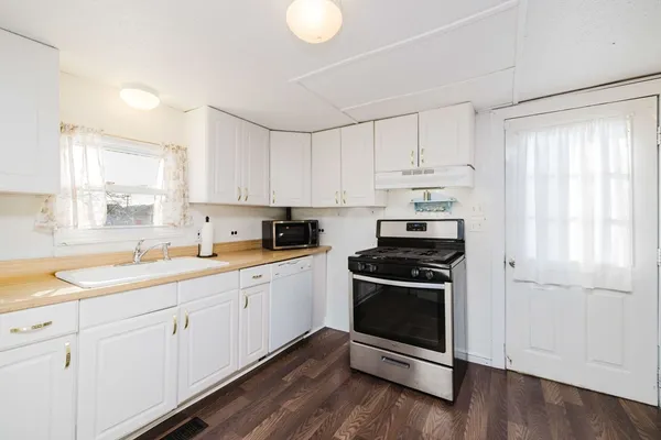 a kitchen with cabinets appliances a sink and a window
