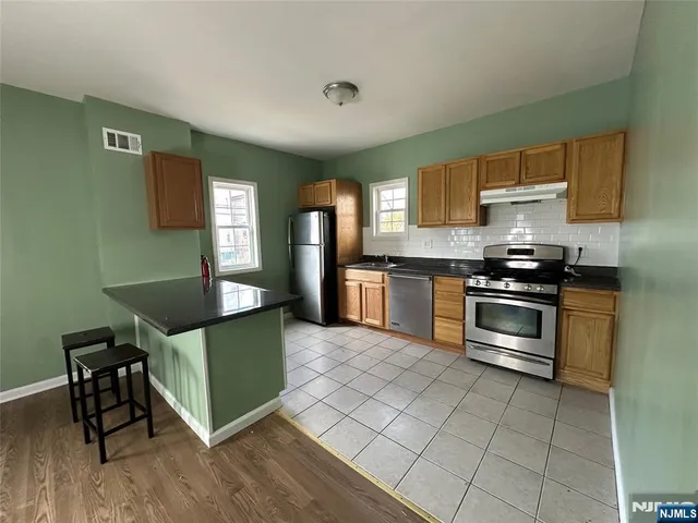 a kitchen with granite countertop a stove cabinets and a refrigerator