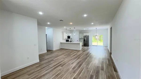 a view of a big room with wooden floor and windows