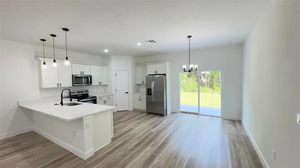 a kitchen with kitchen island a counter top space appliances and a window