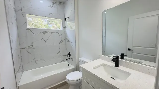 a bathroom with a sink a toilet and bathtub