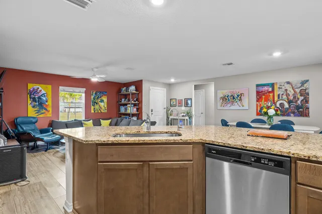 a kitchen with stainless steel appliances granite countertop a sink and a refrigerator