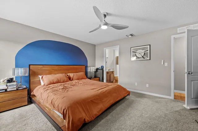 a bedroom with a bed and painting on the wall