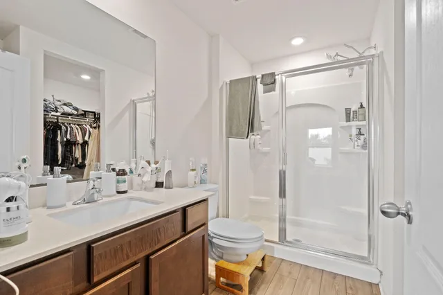 a bathroom with a shower sink vanity mirror and toilet