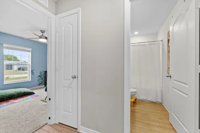 a view of a hallway with wooden floor and closet area