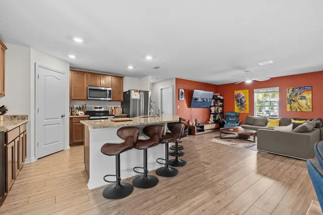 a living room with lots of furniture and kitchen view