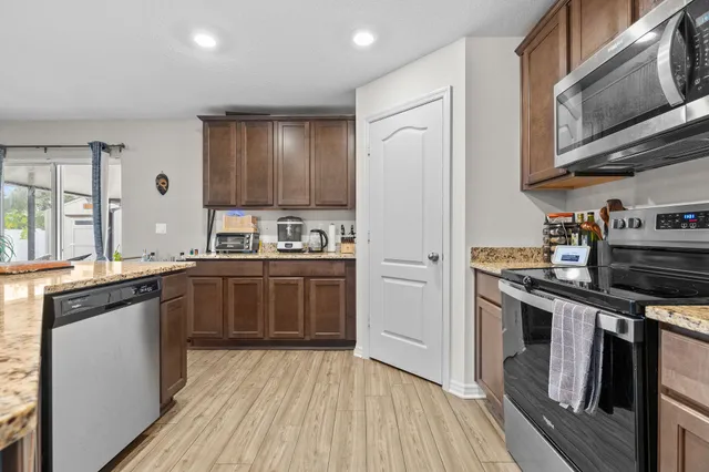 a kitchen with stainless steel appliances granite countertop a stove cabinets and wooden floor