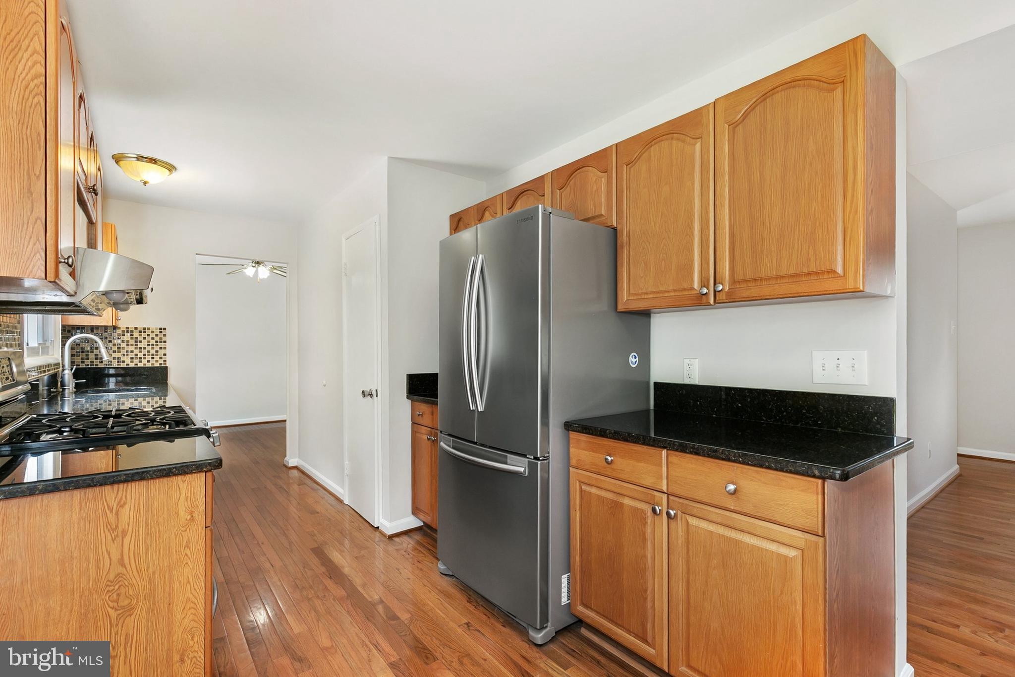 11501 Piney Lodge Road North Potomac, MD 20878 - Photo 13 of 64 a kitchen with granite countertop stainless steel appliances a stove top oven a sink and cabinets