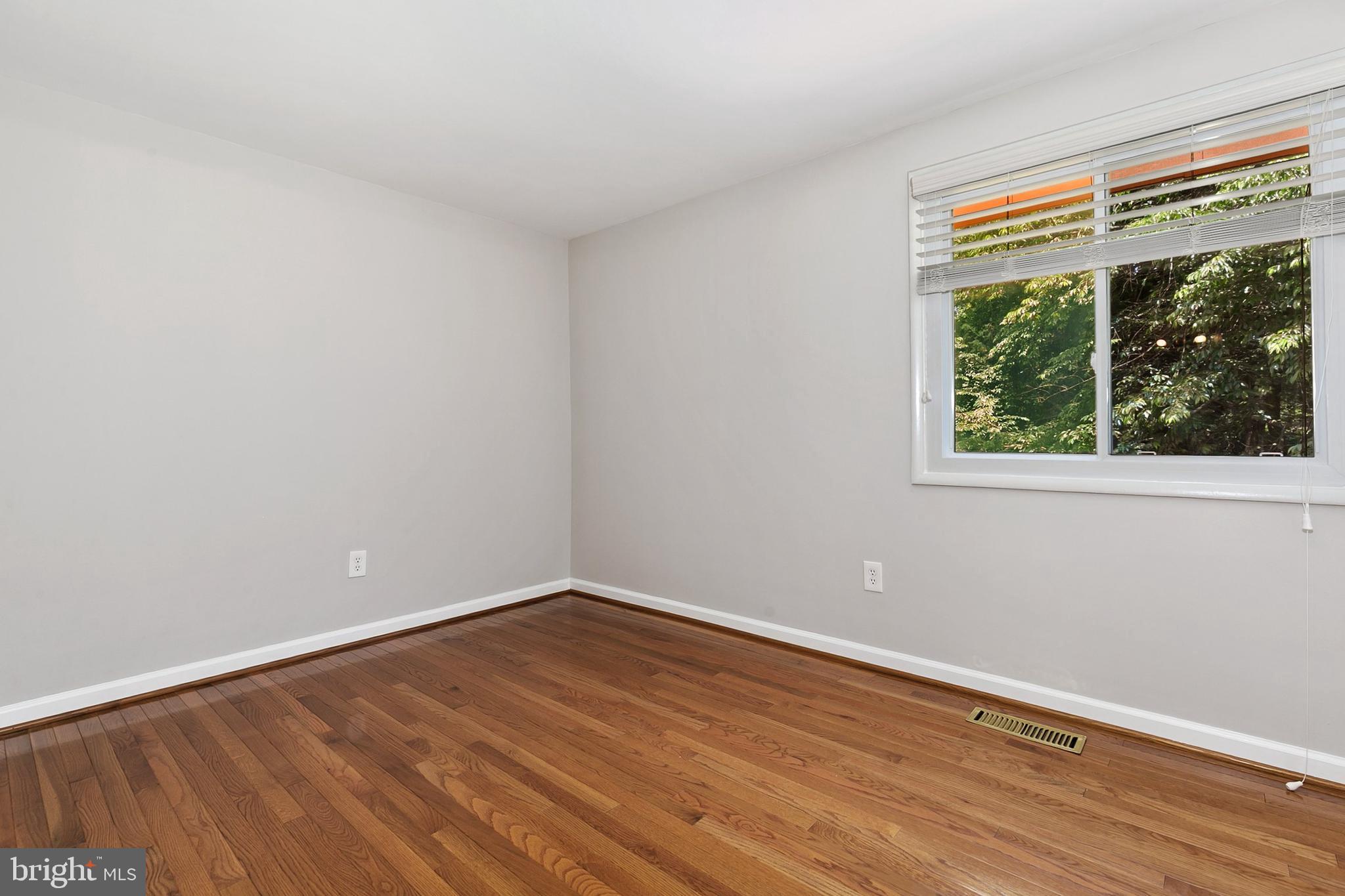 11501 Piney Lodge Road North Potomac, MD 20878 - Photo 27 of 64 a view of an empty room with wooden floor and a window