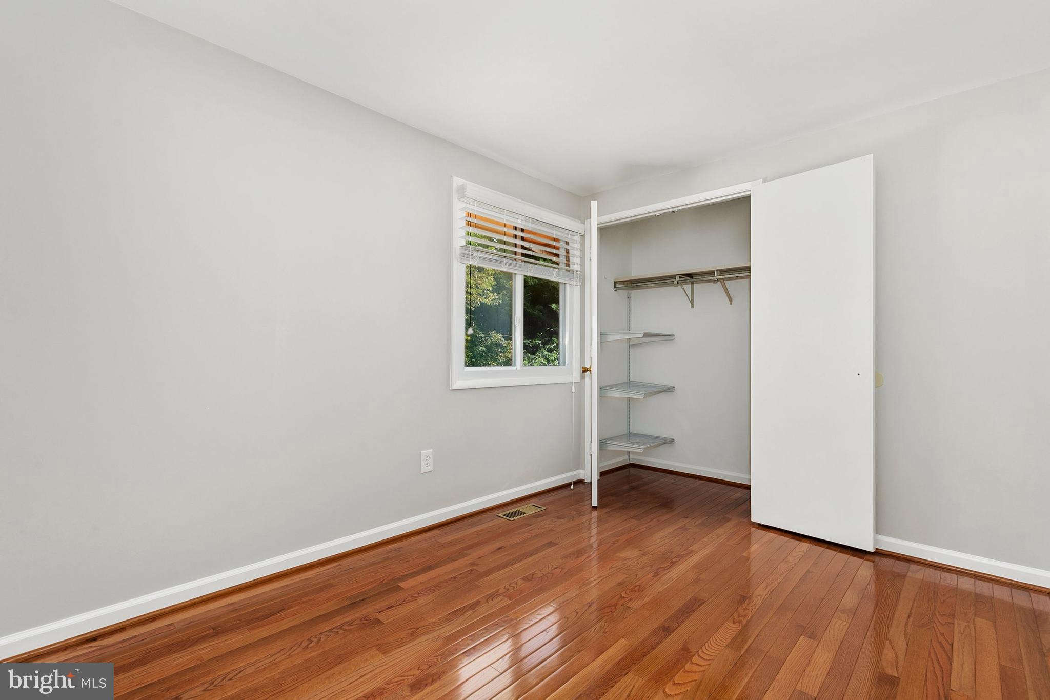 11501 Piney Lodge Road North Potomac, MD 20878 - Photo 28 of 64 an empty room with wooden floor and a window